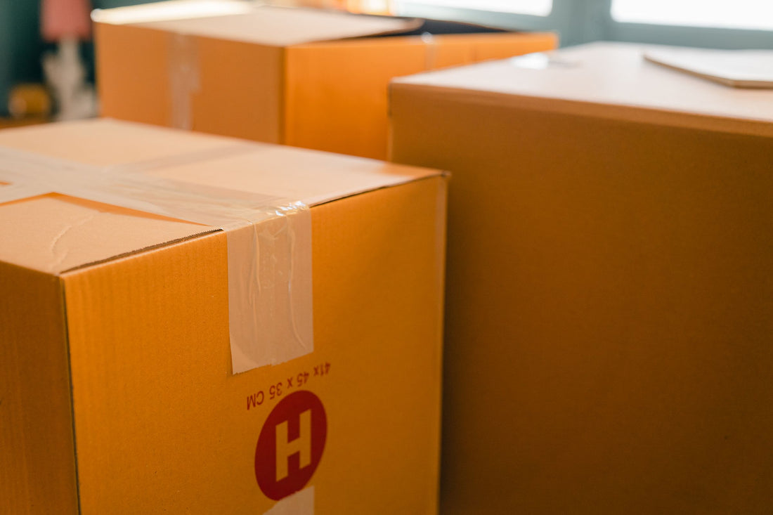 Cartons de déménagement fermés avec du ruban adhésif, posés près d'une fenêtre