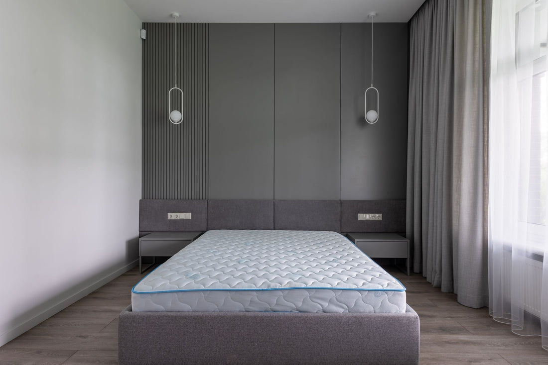 Lit avec matelas moderne et confortable dans une chambre spacieuse aux tons gris