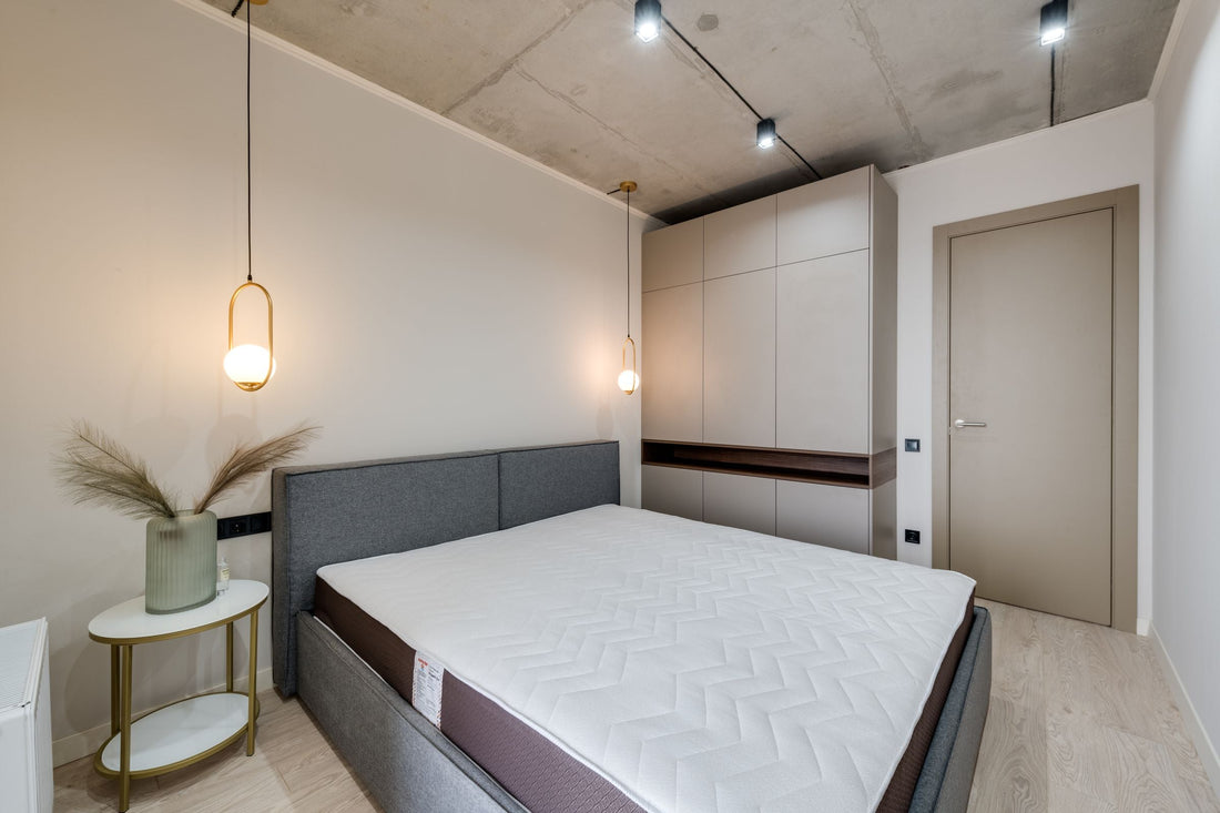 Chambre minimaliste avec lit gris et rangements intégrés discrets