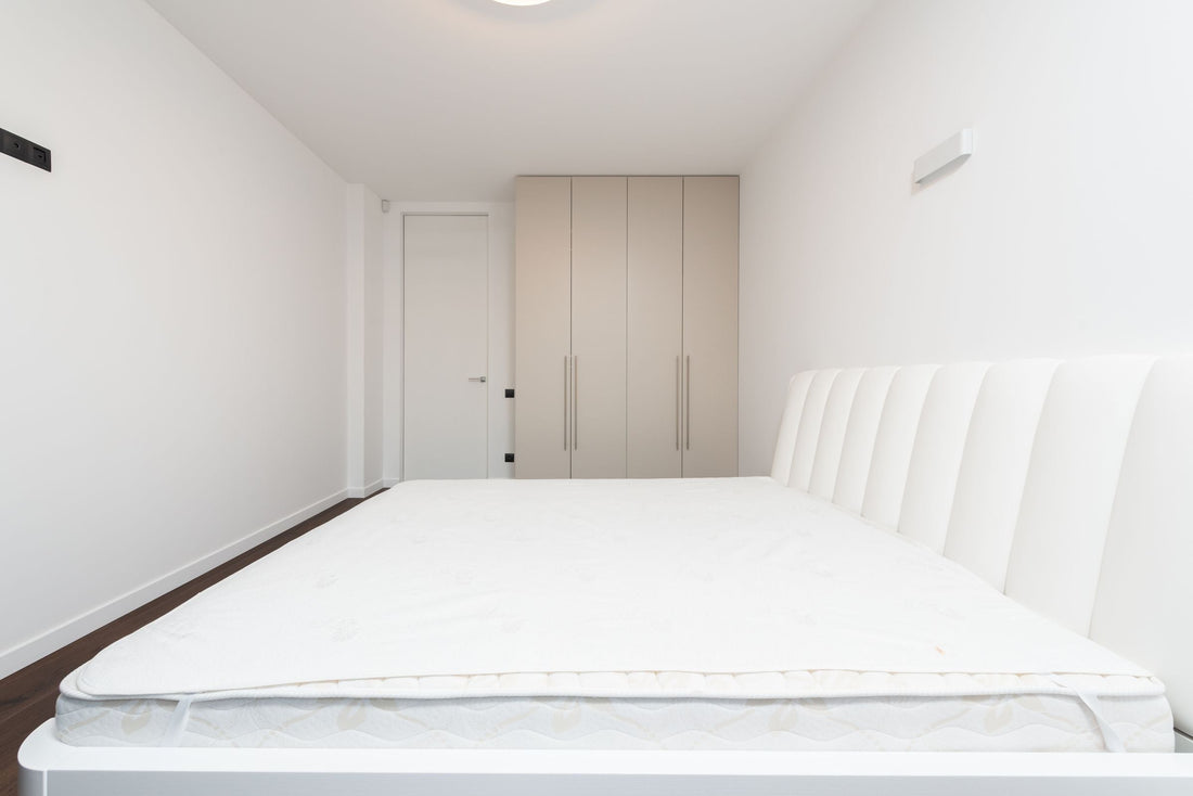 Matelas blanc posé sur un sommier dans une chambre minimaliste contemporaine