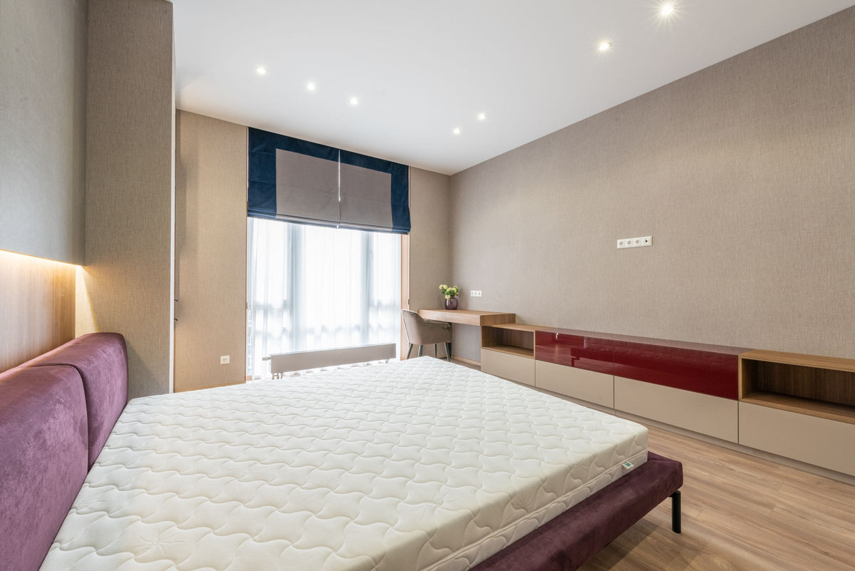 Matelas blanc posé sur un lit en bois dans une chambre moderne — collection sommiers à venir