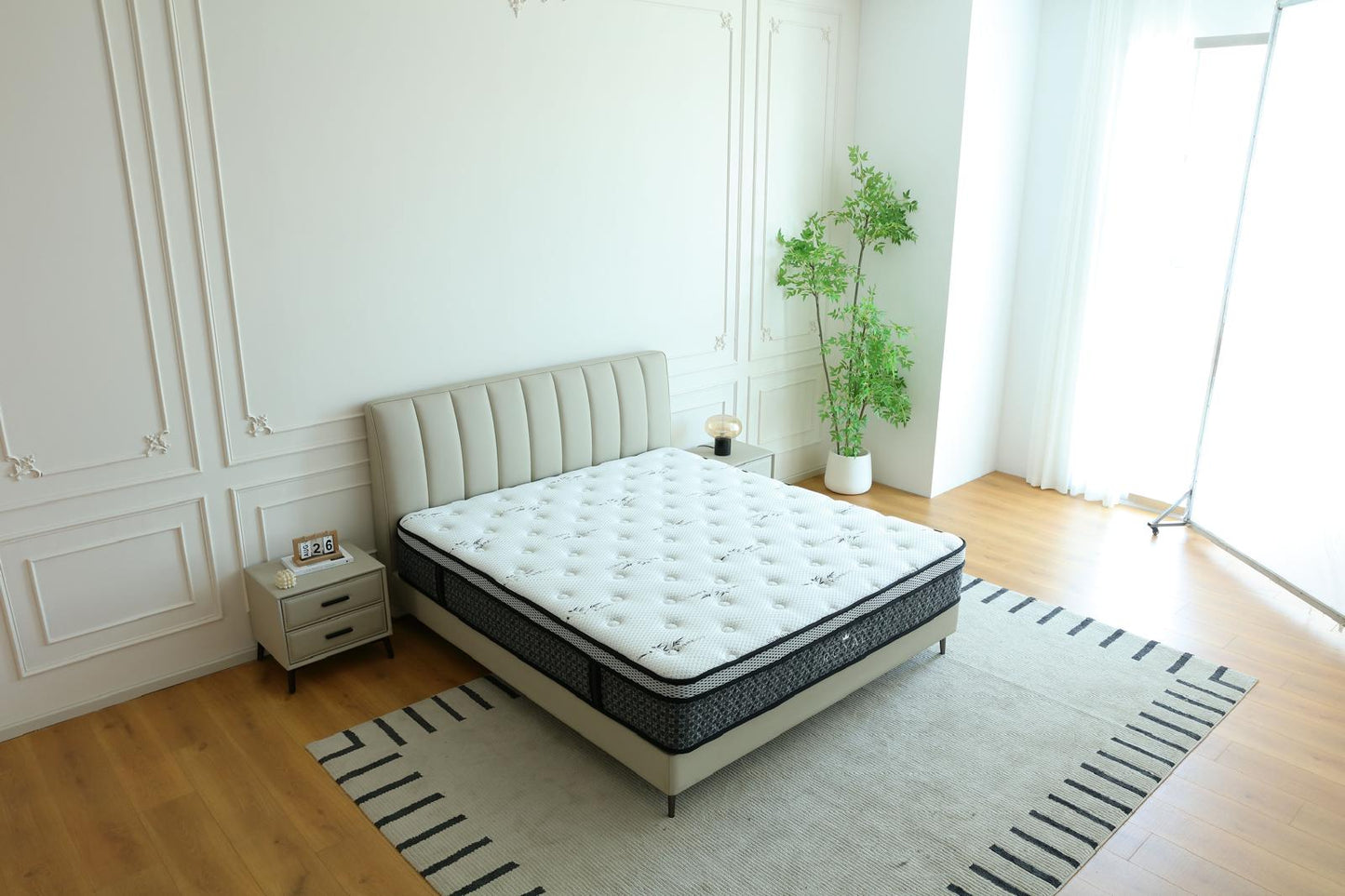 Matelas Royal posé sur un lit à tête de lit capitonnée beige, dans une chambre lumineuse