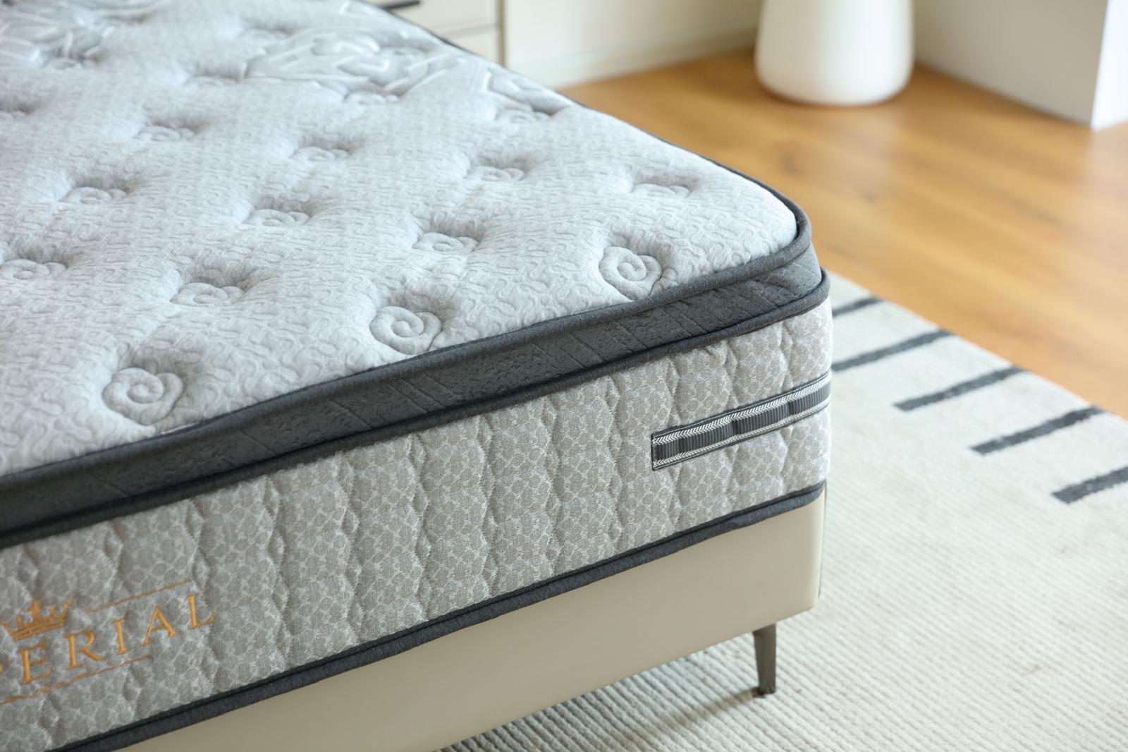 Coin du matelas Imperial sur son sommier, avec le logo doré visible sur le bandeau latéral