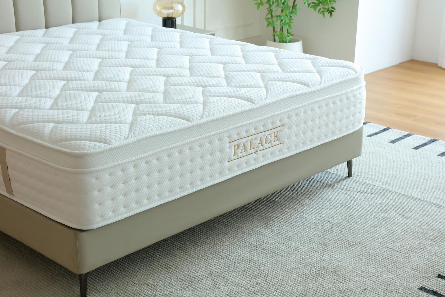 Matelas Palace posé sur son sommier beige, logo doré visible sur le bandeau latéral
