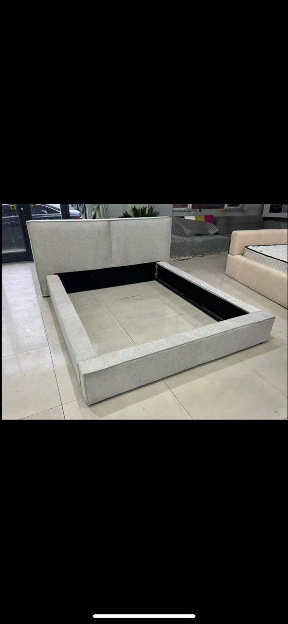 Lit coffre Tanya en tissu gris clair, coffre de rangement ouvert et vide, vu de dessus