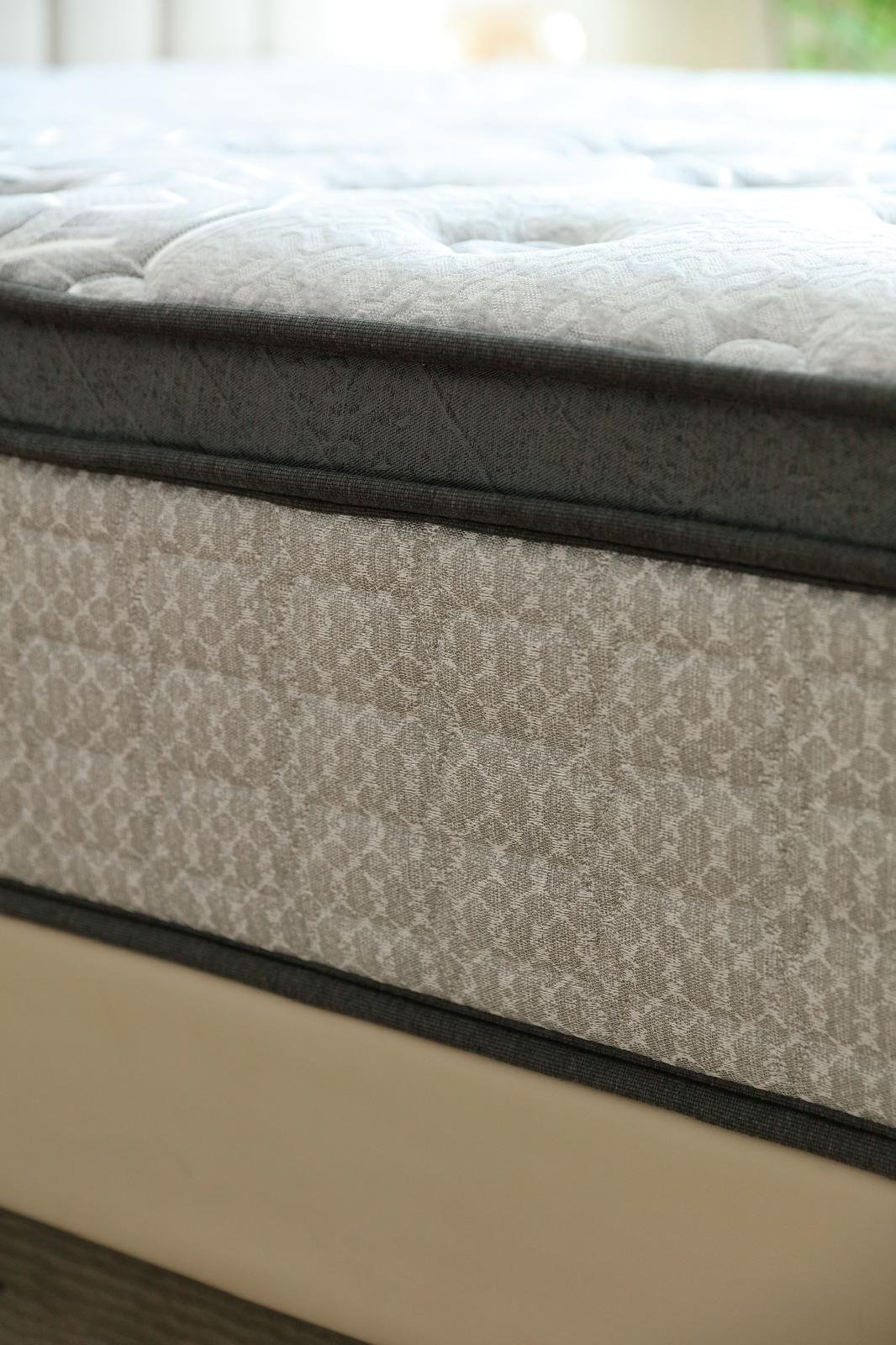 Gros plan sur la tranche du matelas Imperial posé sur son sommier beige