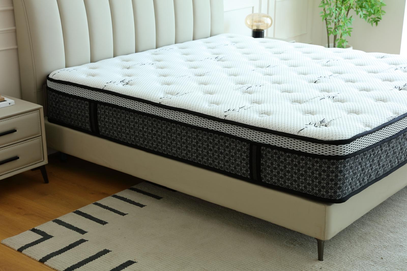 Matelas Royal vu de côté sur son sommier beige, devant une tête de lit capitonnée