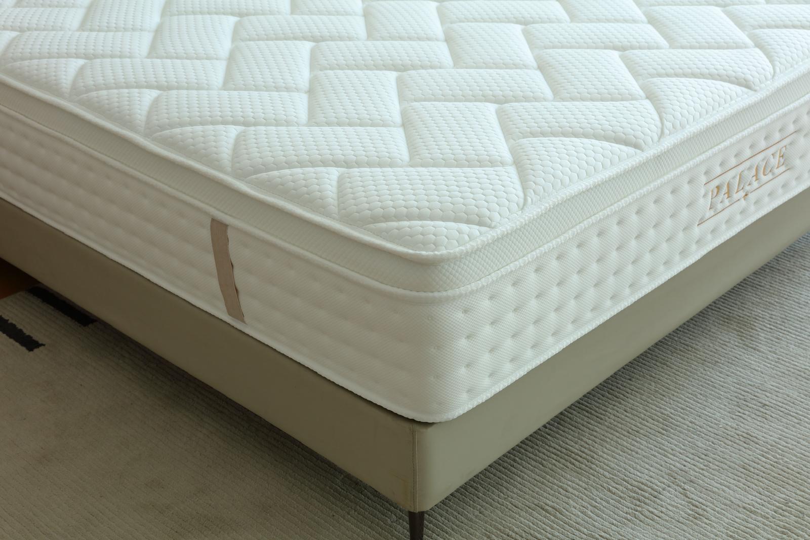 Coin du matelas Palace sur son sommier, détail de la surface matelassée et du bandeau