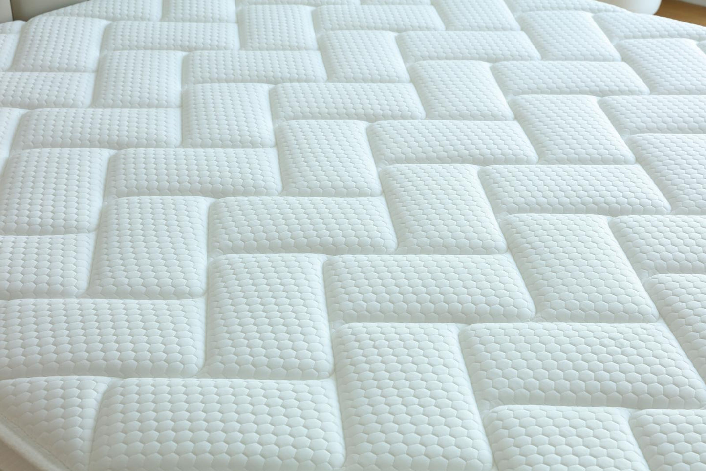 Gros plan sur le motif géométrique du coutil du matelas Palace