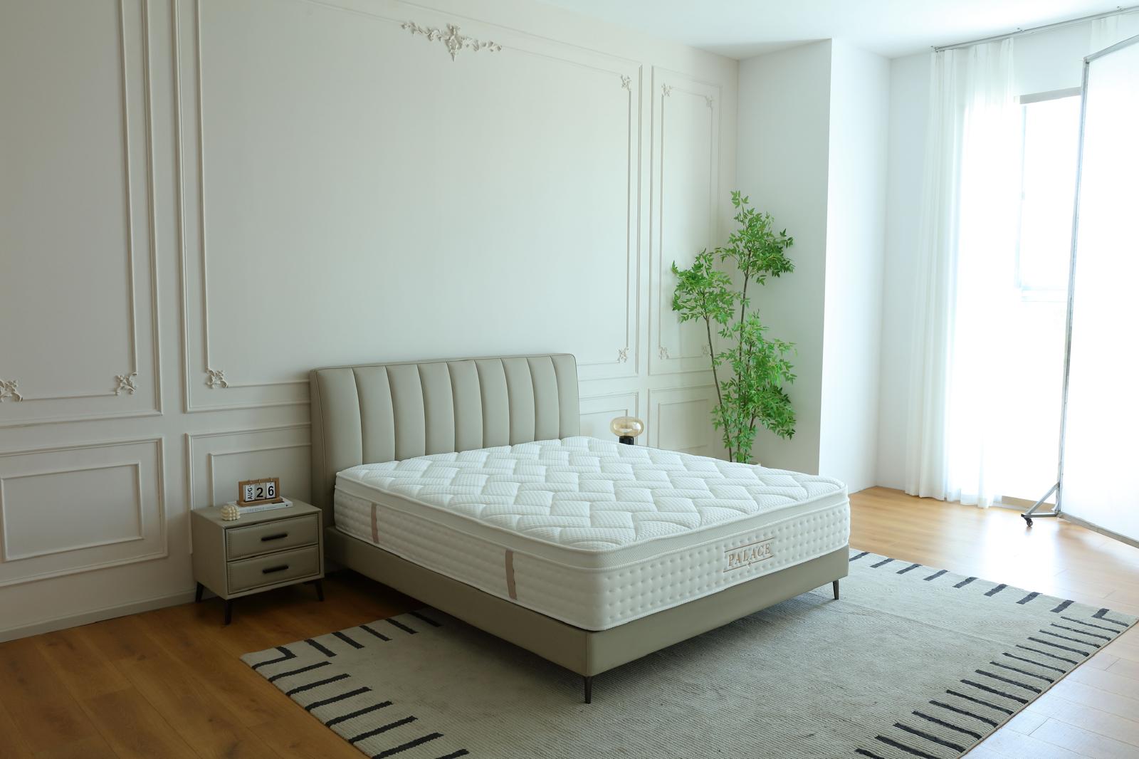 Chambre lumineuse équipée du matelas Palace, près d'une fenêtre habillée de voilage