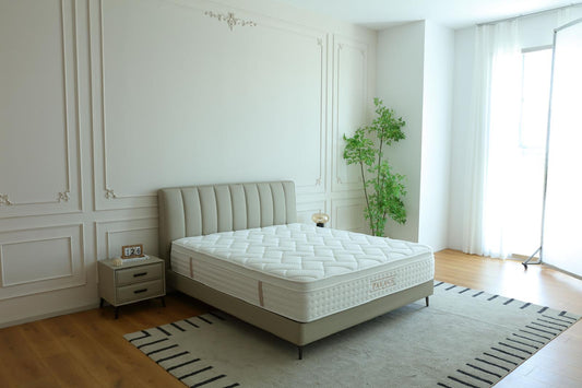 Chambre lumineuse équipée du matelas Palace, près d'une fenêtre habillée de voilage