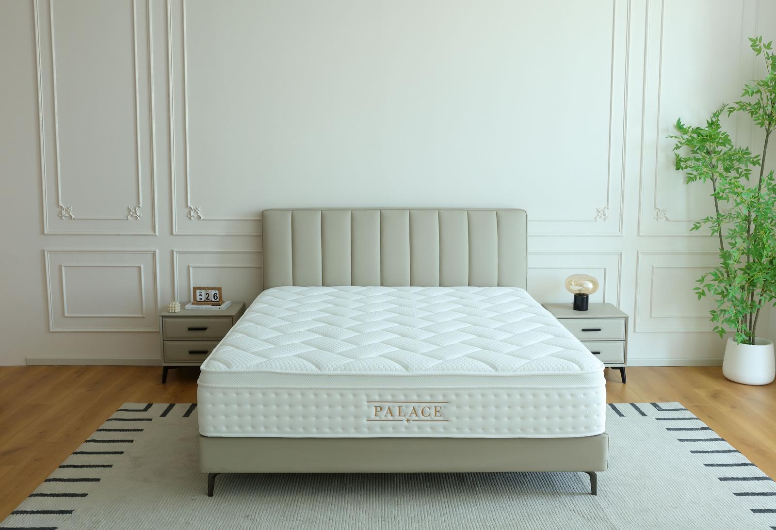 Matelas Palace installé sur un lit à tête de lit capitonnée, dans une chambre au parquet clair
