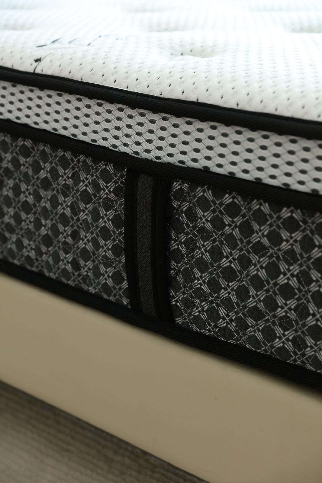 Gros plan sur une poignée latérale du matelas Royal, cousue dans le bandeau noir