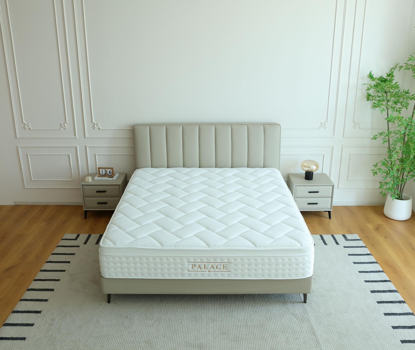 Matelas Palace vu de face sur son lit, entre deux tables de chevet