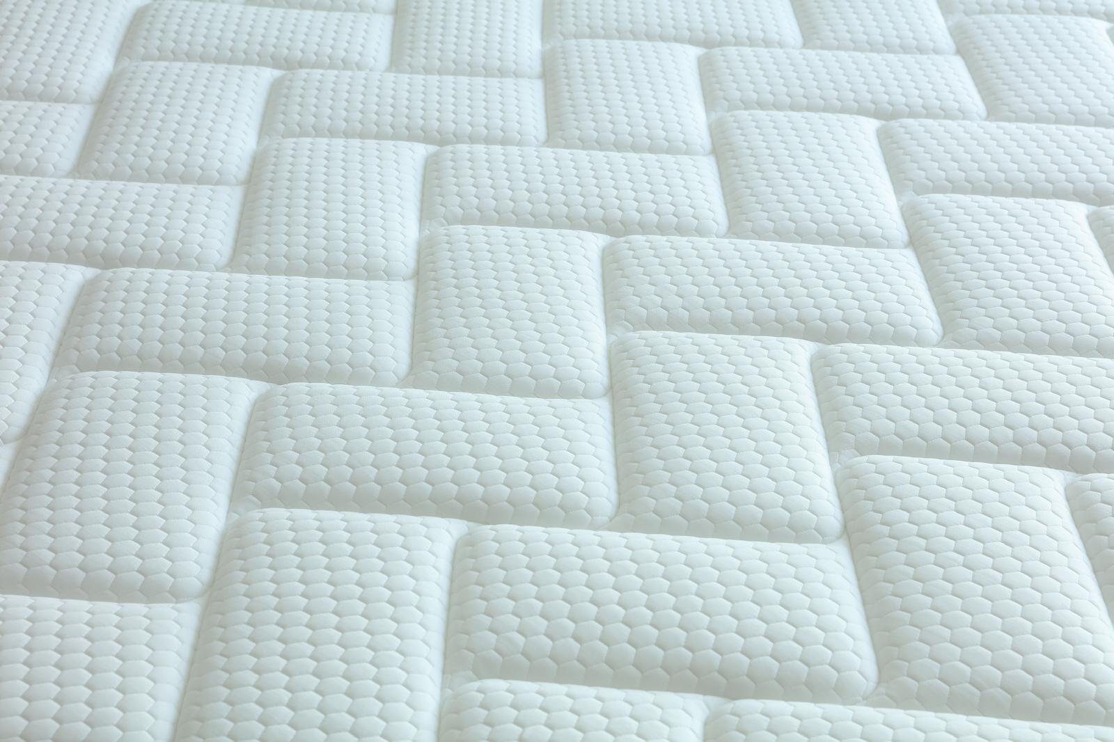 Détail du coutil blanc du matelas Palace, motif géométrique matelassé