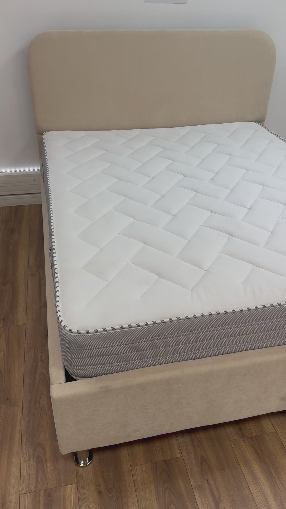Vidéo : vue d'ensemble du lit coffre Jade beige avec son matelas, dans une pièce au sol en bois